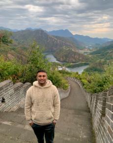 A male students stands at the Great Wall of China